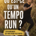 Femme en pleine course réalisant un tempo run sur une piste de jogging.