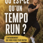 Femme en pleine course réalisant un tempo run sur une piste de jogging.